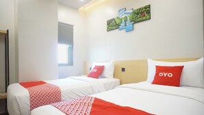 Two beds with white and red bedding, a painting on the wall, and a window in the background. - OYO 92956 Travelbiz Hotel (Medan)
