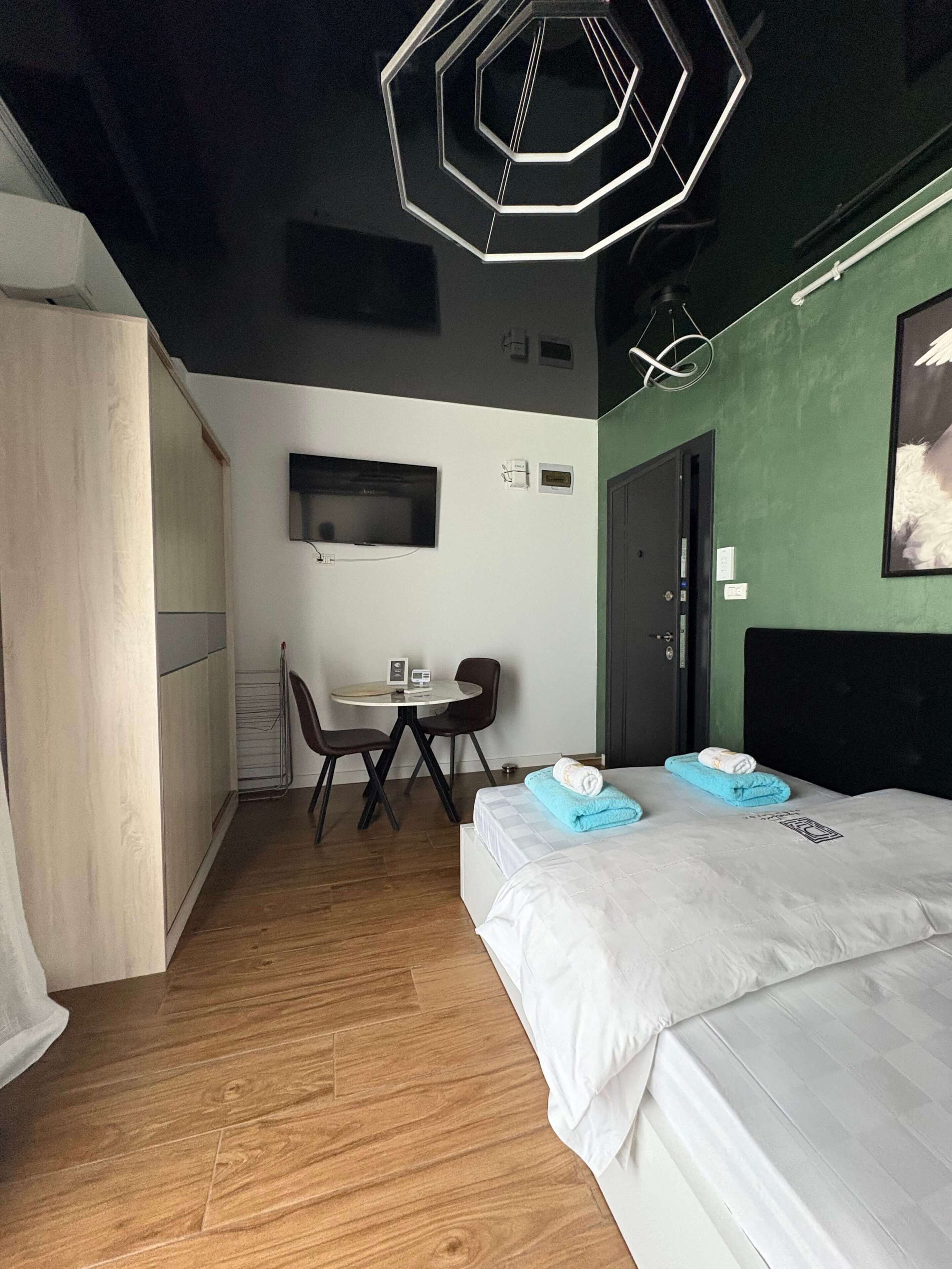 Une chambre d’hôtel avec un lit, un bureau, une chaise, une télévision et une porte.