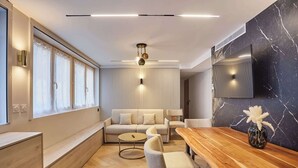 Een moderne woonkamer met een bank, salontafel en eettafel.