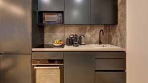Een moderne keuken met een magnetron, koffiezetapparaat en broodrooster op het aanrecht, en een vaatwasser eronder.