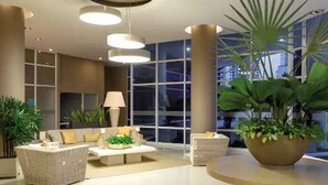A modern lobby with a sofa, coffee table, and potted plants. - Majestic 3BR With Fantastic Pool in Bolivar (Santa Marta)