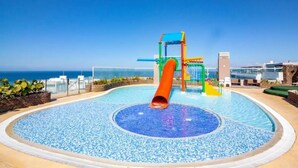 A pool with a slide and play structure, surrounded by a clear blue sky and a view of the ocean. - Majestic 3BR With Fantastic Pool in Bolivar (Santa Marta)