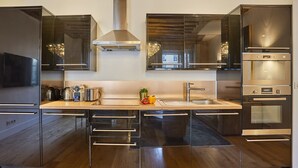 Une cuisine moderne dotée d’appareils électroménagers en acier inoxydable, d’un îlot central et d’une grande fenêtre.