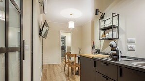 A modern kitchen with a wooden dining table, a built-in oven, and a coffee machine. - Welchome suites (Perugia)
