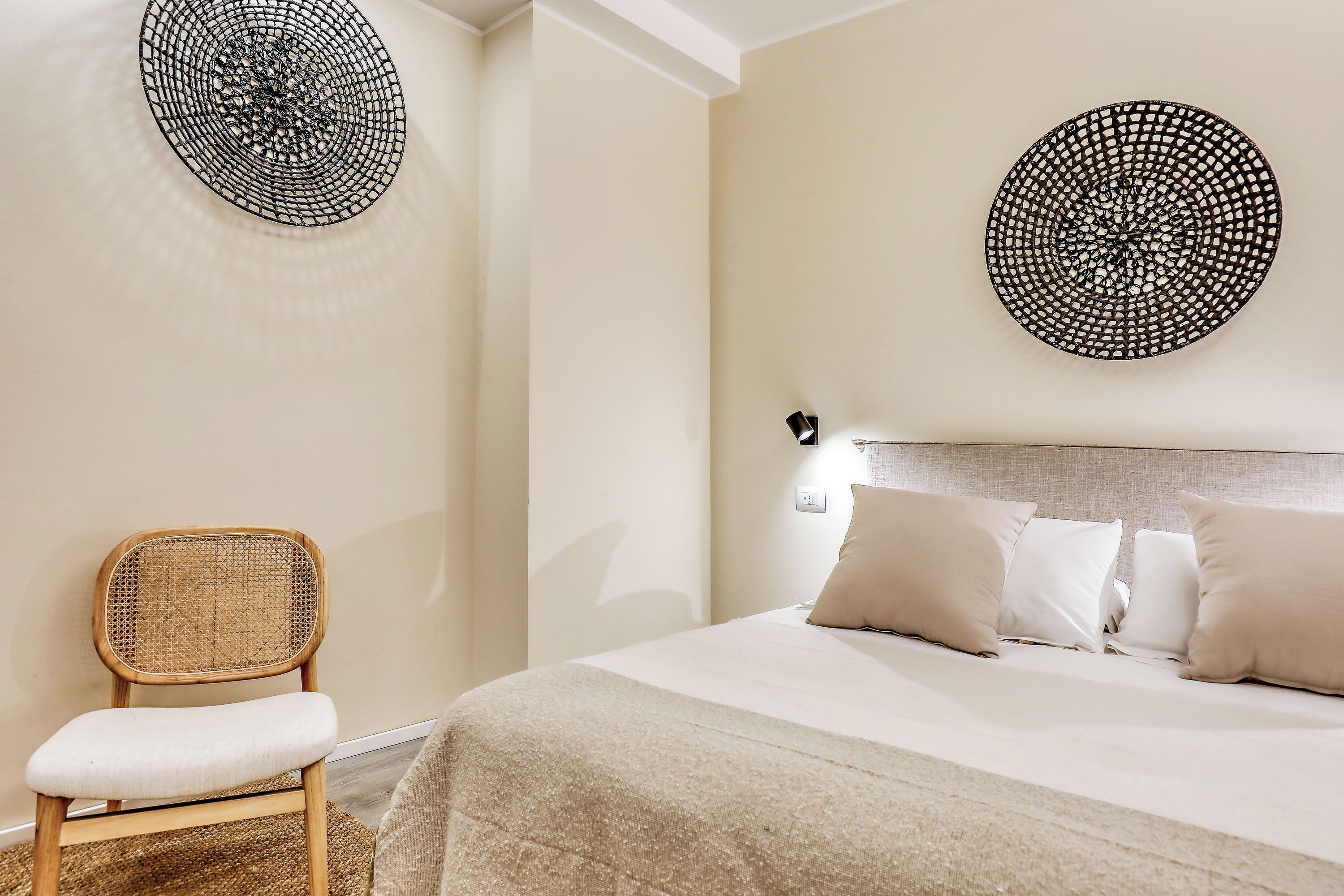 Une chambre à coucher comprenant un lit, une chaise et deux éléments décoratifs fixés au mur.
