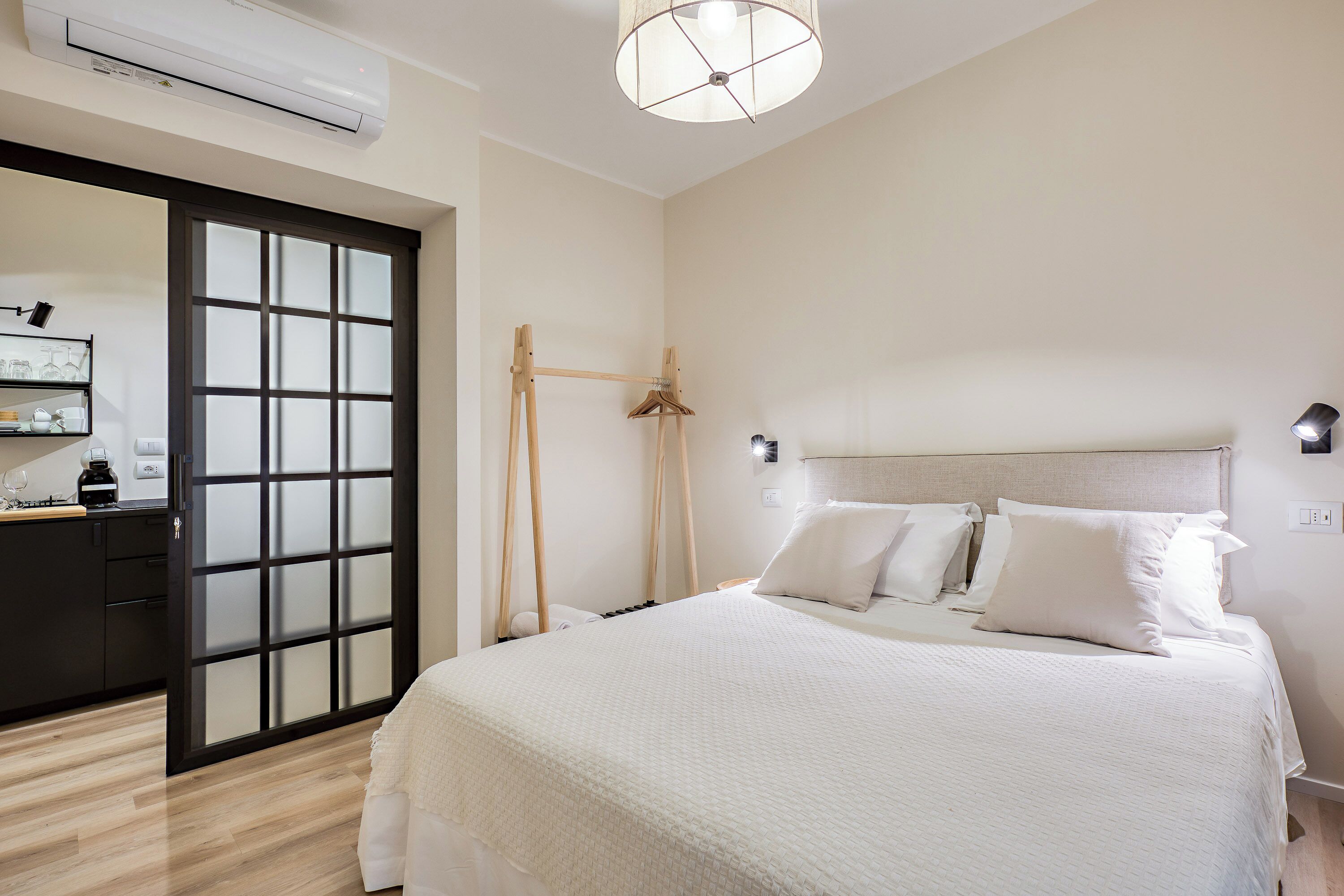 A bedroom with a bed, bedside table, and a wardrobe.