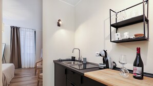 A modern kitchen with a sink, countertop, and wine bottle. - Welchome suites (Perugia)