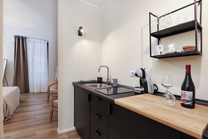 Cocina moderna con lavabo, encimera y botella de vino.