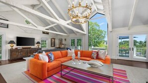 A spacious living room with a large sectional sofa, a chandelier, and a flat-screen TV. - Luxury rental with pool. Close to village and beach RPMS157 (Osterville)