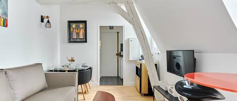 Un loft moderno con techos altos, un comedor, una cocina y una sala de estar con sofá y mesa de centro.