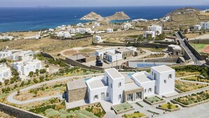 A coastal village with white buildings, a swimming pool, and a view of the sea. - Pristine Villa With Swimming Pool (Mykonos)