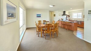 A spacious kitchen with wooden cabinets, a central island, and a dining area with a large table and chairs. - No. 8 - 200m to the best coffee in town and main street (Robe)