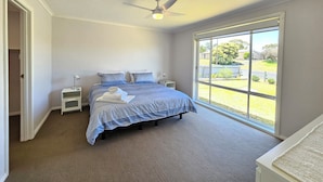 A bedroom with a bed, a ceiling fan, bedside tables, a window with a view of the outside. - No. 8 - 200m to the best coffee in town and main street (Robe)