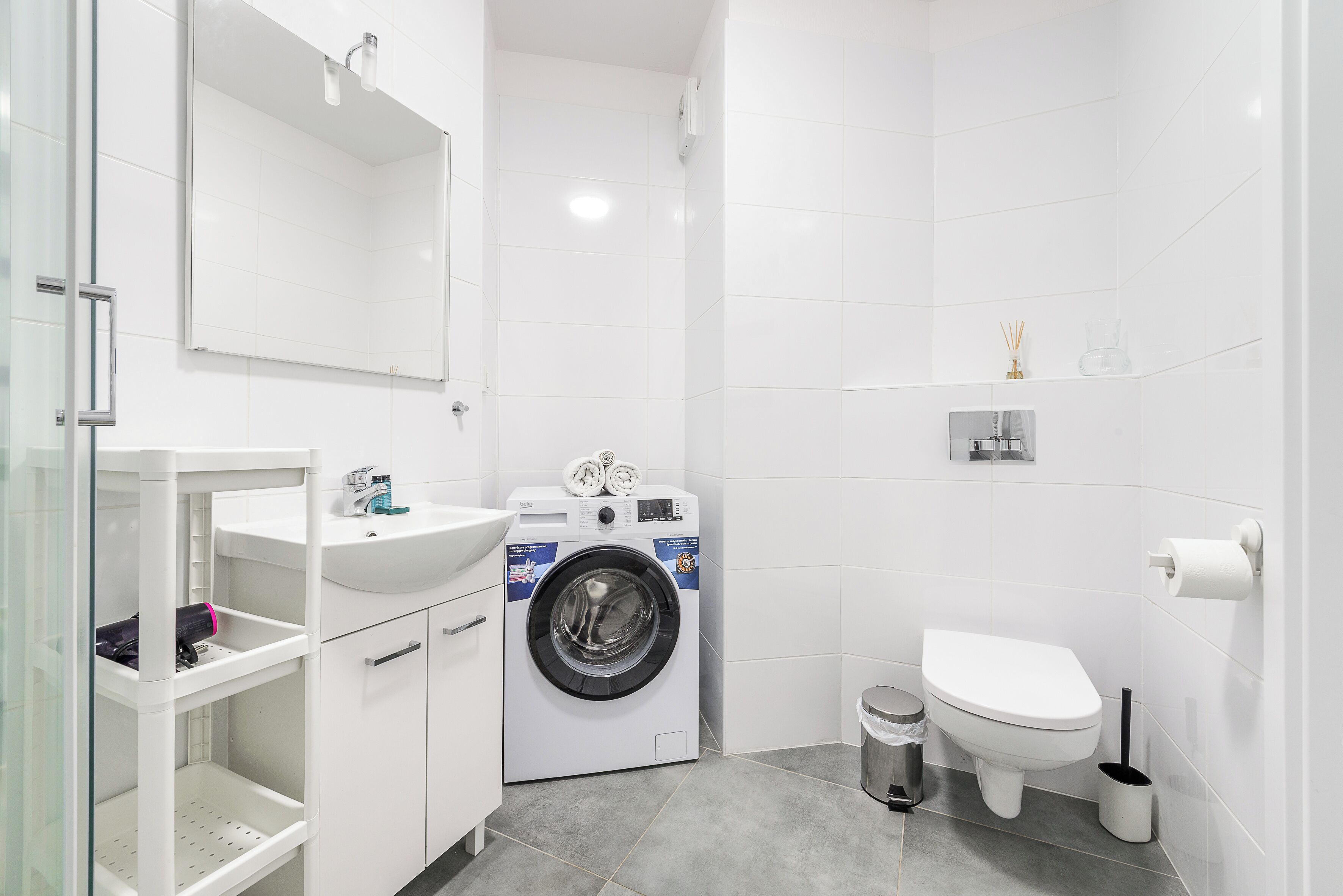 Un baño moderno con lavadora integrada, inodoro y lavamanos.