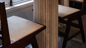 Ein runder Tisch mit Holzboden und zwei Korbstühle.