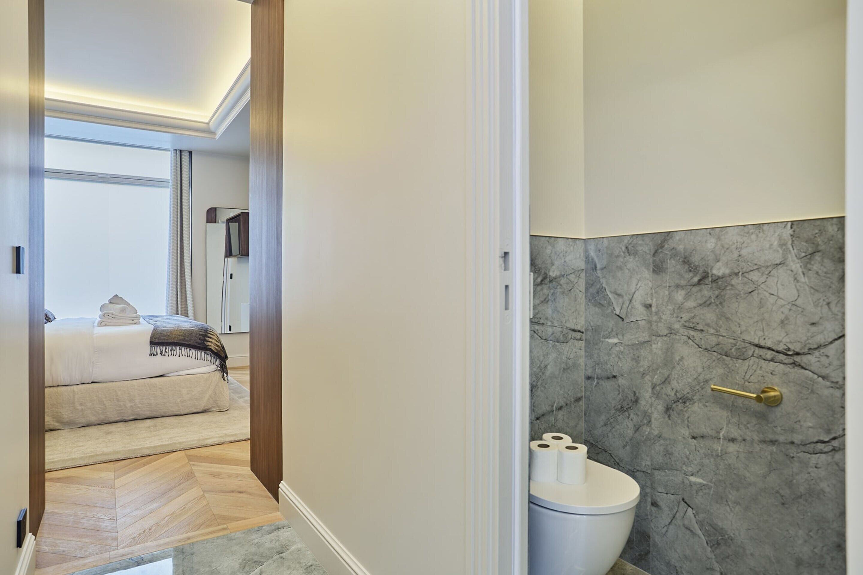 Un bagno moderno con una parete in marmo e un water.