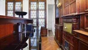 Una habitación con paneles de madera, una encimera de madera pulida y un amplio ventanal con vidrieras.