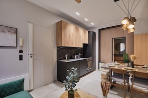 Een moderne keuken met donkere aanrechtbladen, houten kastjes en een eethoek met een houten tafel en stoelen.