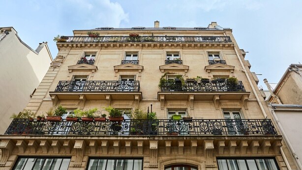 Un edificio de varios pisos con balcones decorados, ventanas grandes y un estilo arquitectónico clásico.