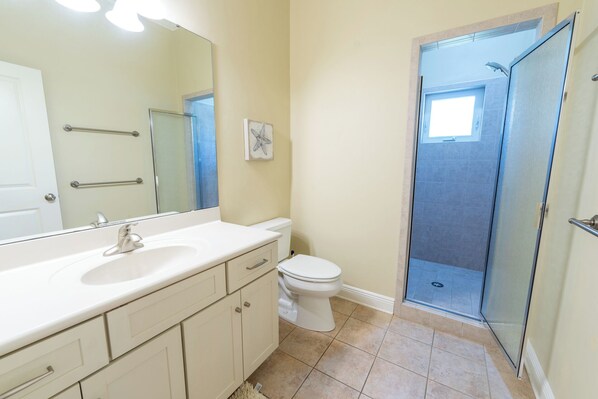 A bathroom with a white sink, a toilet, a shower, and a large mirror. - Back on the Rental Market! Dog-Friendly, 4BR/4BA w/ Pool! (St. George Island)