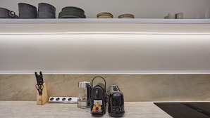 A kitchen with a countertop, a coffee maker, a toaster, and a knife block.
