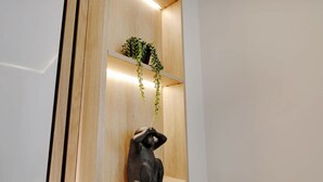 A wooden shelf unit with a potted plant and a black sculpture. - Sublime Apartment in the Heart of Paris (Paris)