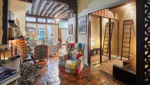 A cozy living room with a fireplace, zebra-patterned sofa, and a colorful armchair. - Superbe Apartment Le Marais/place des Vosges (Paris)