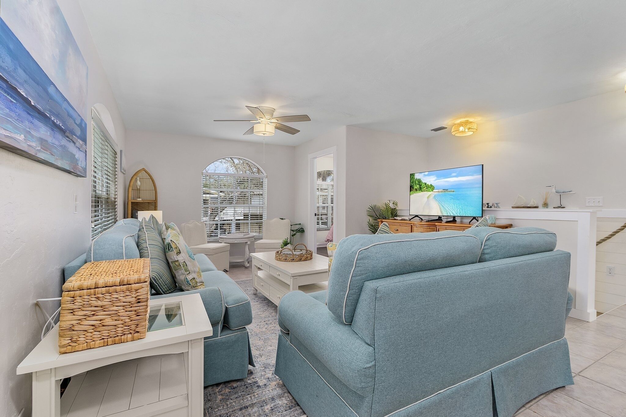 A modern living room with a sofa, TV, and decorative items.