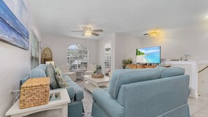 Ein modernes Wohnzimmer mit einer Couch, einem Fernseher und Dekorationselementen.