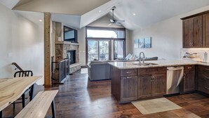 A spacious kitchen with wooden cabinets, a built-in dishwasher, and a large island with a sink. - Luxury Home - Sleeps 10 - Fireplace & Mountain View 3 Bedroom Condo (Keystone)