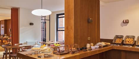 Una barra de desayuno con una variedad de alimentos y un diseño interior moderno.