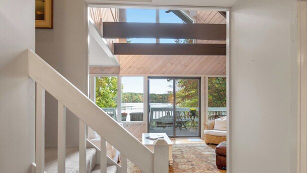Una escalera conduce a una terraza con mobiliario exterior y vistas del entorno.