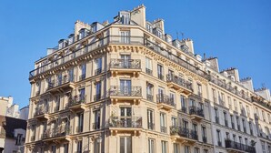 Ein mehrstöckiges Gebäude mit aufwendigen Balkonen und klassischer Architektur.