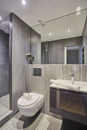 Un bagno moderno con WC, bidet e lavandino.
