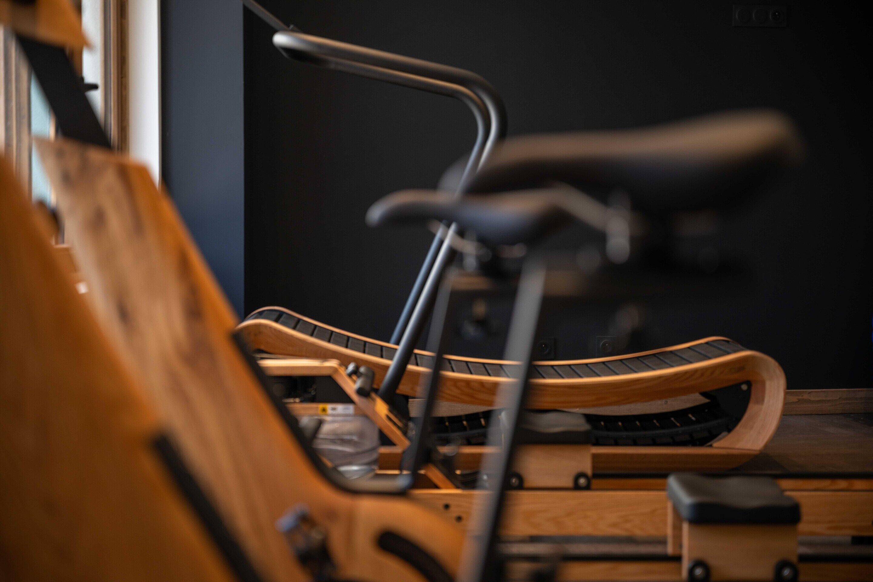 A close-up of a wooden chair with a curved backrest and metal armrests.