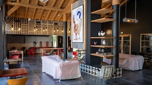 A spacious indoor area with high ceilings, wooden beams, and modern lighting fixtures. There are covered seating areas and a bar/lounge area in the background. - Charming Apt With View 2bd/6p -residence in Mega\"ve (Megeve)