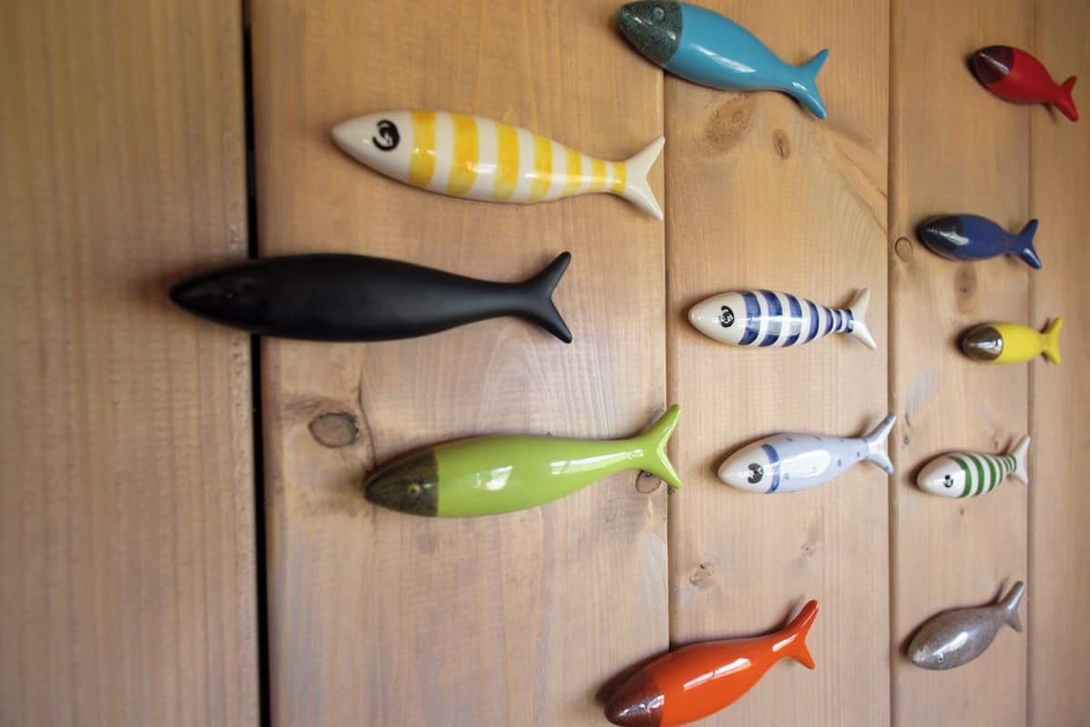 Différents objets en forme de poisson disposés sur une surface en bois.