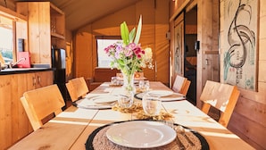 Ein Holztisch gedeckt mit Tellern, Besteck und einer Blumenarrangement.
