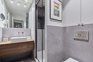 A modern bathroom with a wooden vanity, a large mirror, and a shower area. - Magnificent new Apartment Notre Dame de Paris (Paris)