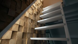 Una escalera moderna con diseño de pared de madera y barandillas blancas.