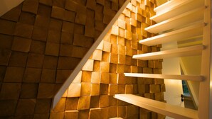 Una escalera con un diseño de pared de madera y barandillas blancas.