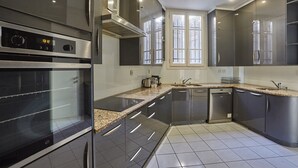 Une cuisine moderne équipée d’appareils électroménagers en acier inoxydable, d’un four encastré et d’un lave-vaisselle.