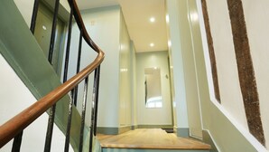 A staircase with wooden steps and black railings leading to a landing.