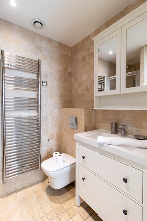 A modern bathroom with a white vanity, a toilet, and a shower area. - Superb and New Studio in the Center of Paris (Paris)