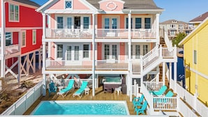 Una casa de varios pisos con piscina, balcones y bañera de hidromasaje.
