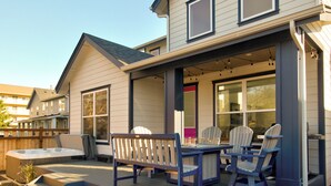 A house with a covered patio area featuring outdoor furniture and a hot tub. - Welcome to your ultimate getaway, Burl by the Bay! (Ocean Shores)