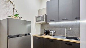 A compact kitchen with a refrigerator, microwave, toaster, and sink. - Apartment Centre de Paris Sacre Coeur (Paris)