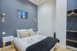 A bedroom with a bed, bedside tables, a wardrobe, and a wall-mounted artwork. - Apartment Centre de Paris Sacre Coeur (Paris)