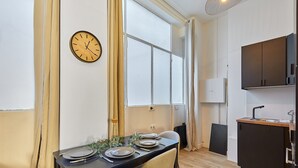 A modern kitchen with dark cabinets, a wooden countertop, and a built-in oven. - Suite Saint Germain des Pres Rue de Rennes (Paris)