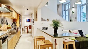 Una cucina moderna con mobili in legno, elettrodomestici in acciaio inossidabile e un'isola centrale con sgabelli.